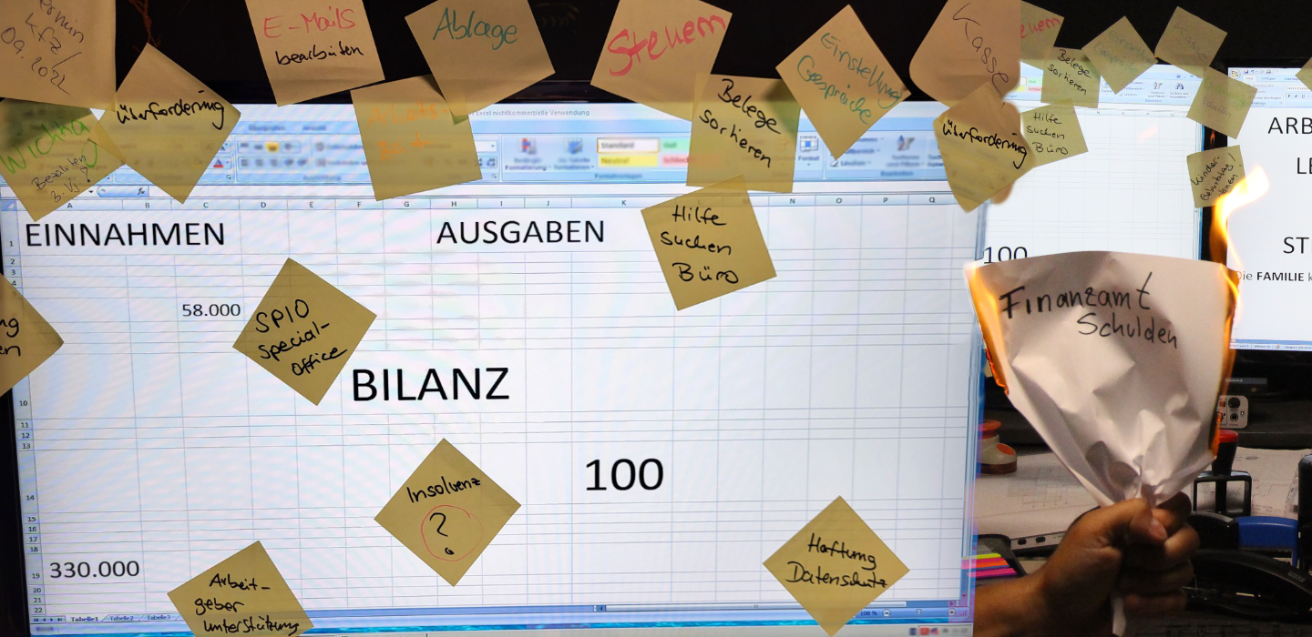 Überfüllter Schreibtisch, PC Bildschirme mit vielen Notizzetteln wie z.B. Überforderung, Insolvenz, Steuern, Hilfe...